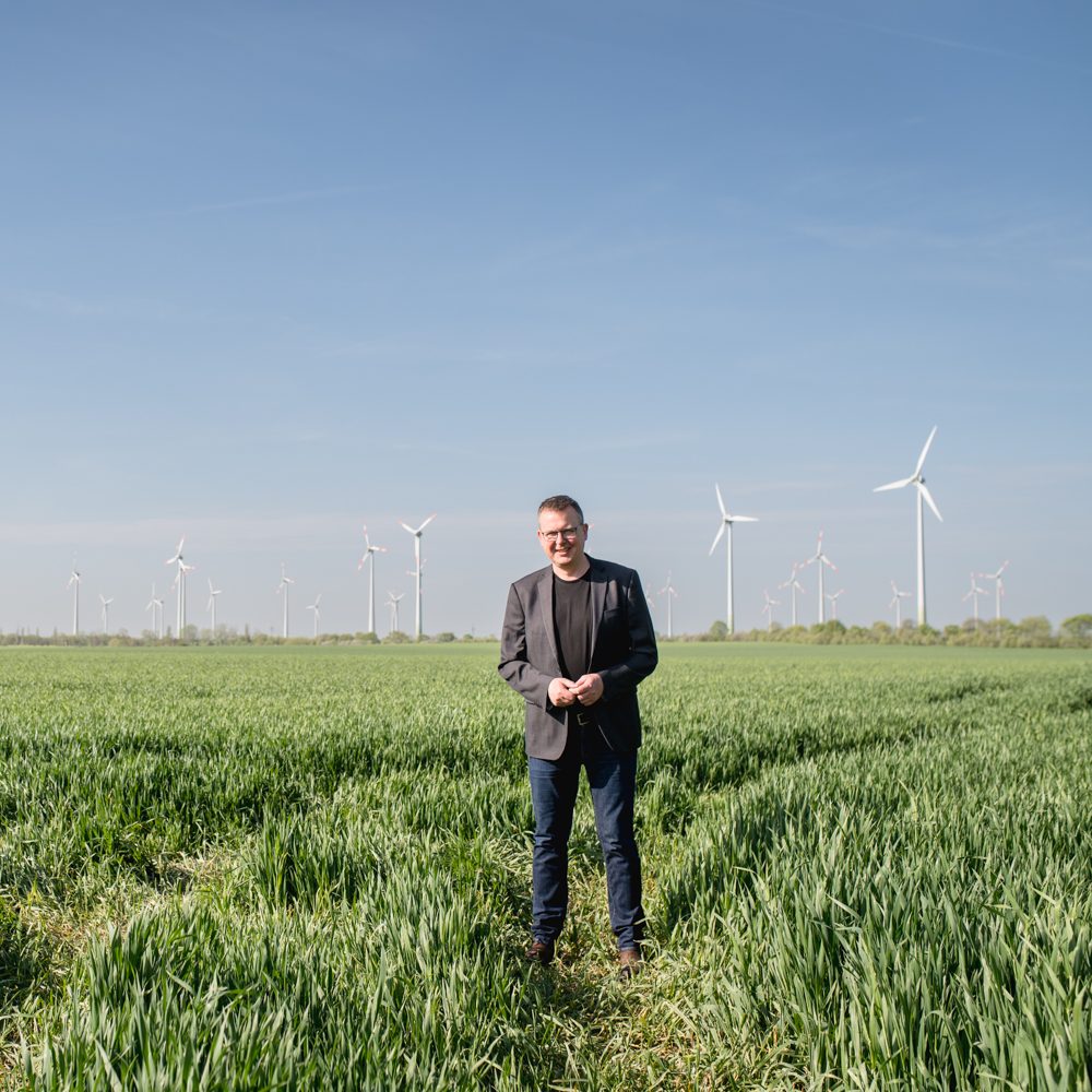 Johannes Funke vor den Windrädern in Nauen